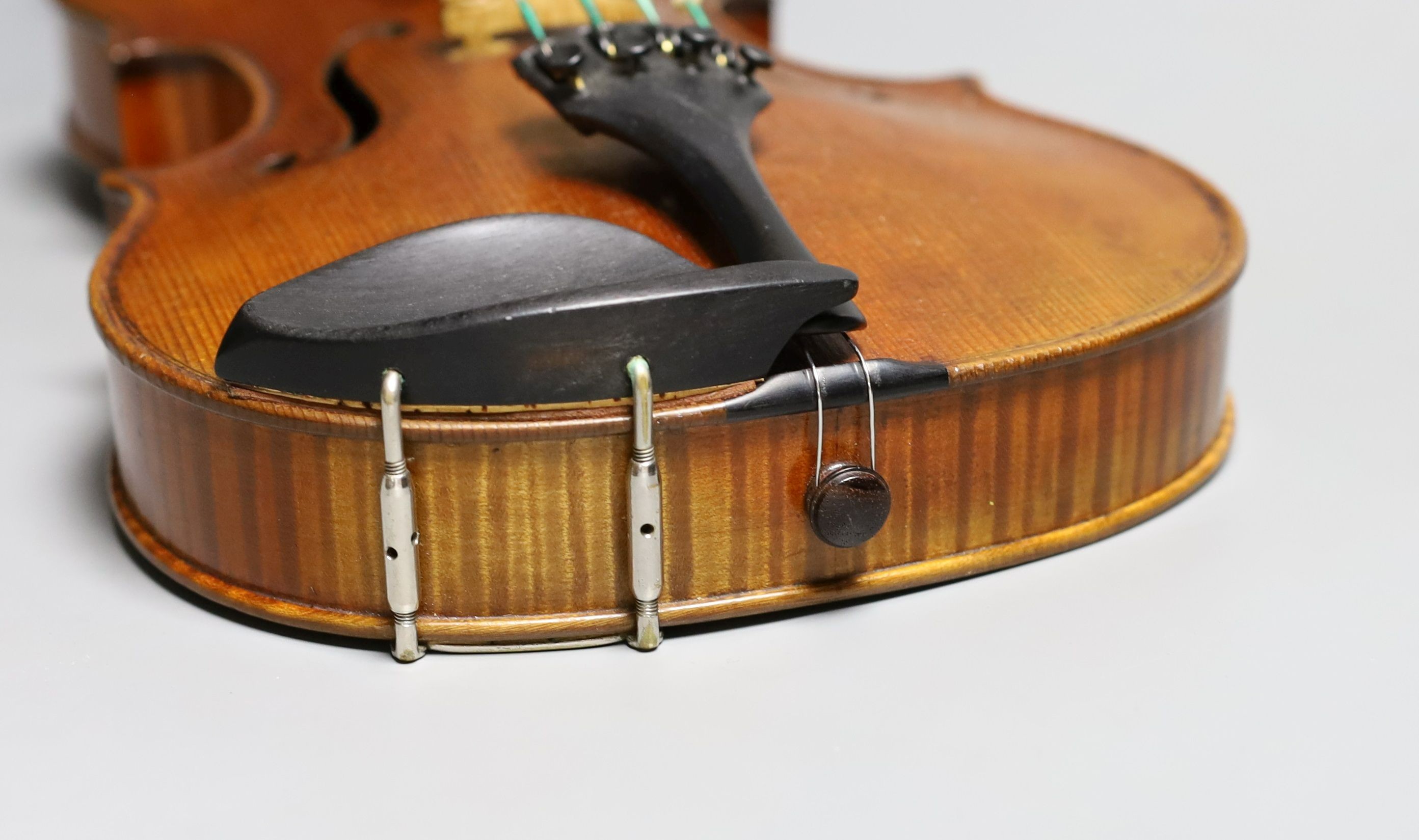 A 19th century violin labelled JB Guadagnini, back measures 35cm, with two bows, one silver-mounted.